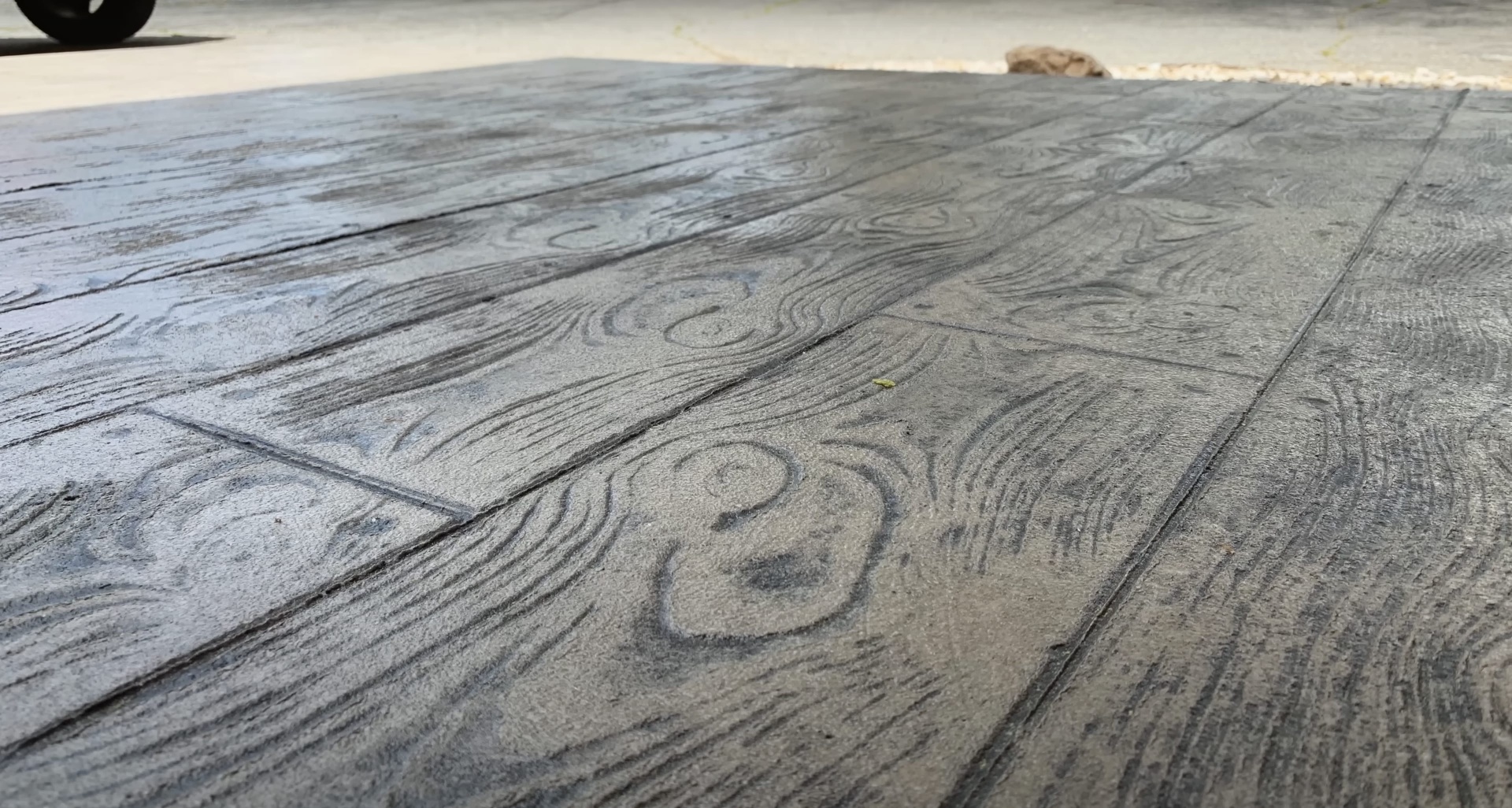 Detailed view of stamped concrete with realistic wood grain stamping Close-up of stamped concrete surface with detailed wood grain texture and pattern