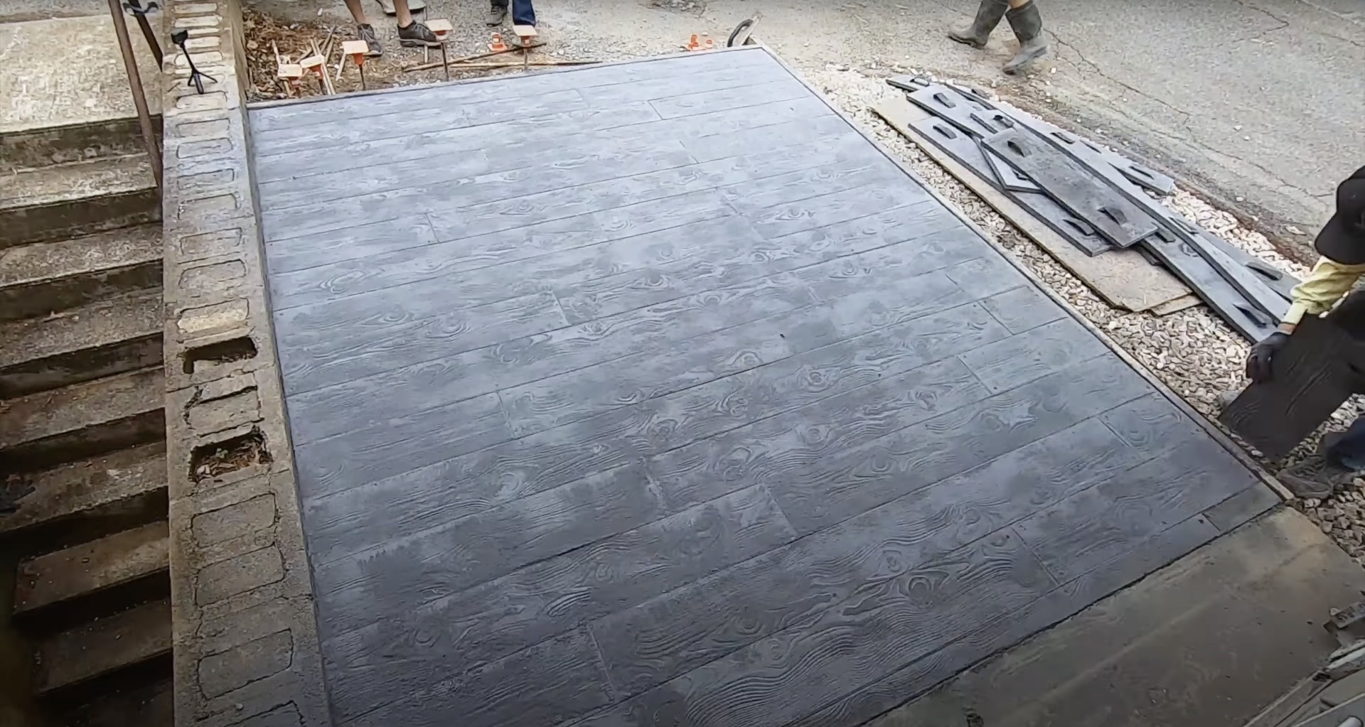 Stamped concrete patio with decorative wood grain pattern Freshly poured stamped concrete patio with wood grain pattern during construction