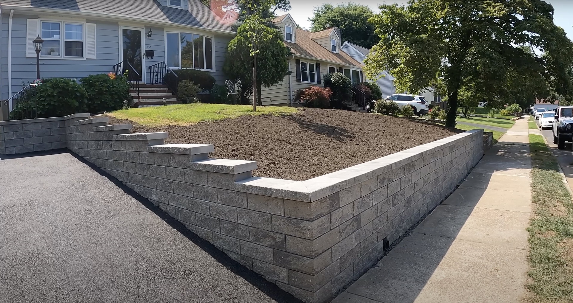 Professional concrete retaining wall installation in residential setting Concrete retaining wall construction with interlocking blocks for residential landscaping project