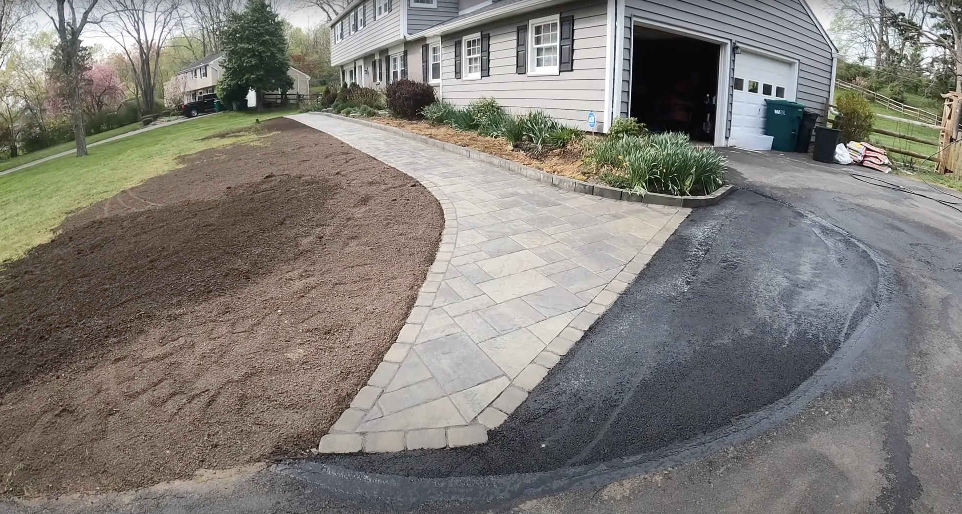 Custom concrete walkway and paver design for residential entrance Decorative concrete walkway and paver installation connecting driveway to home entrance