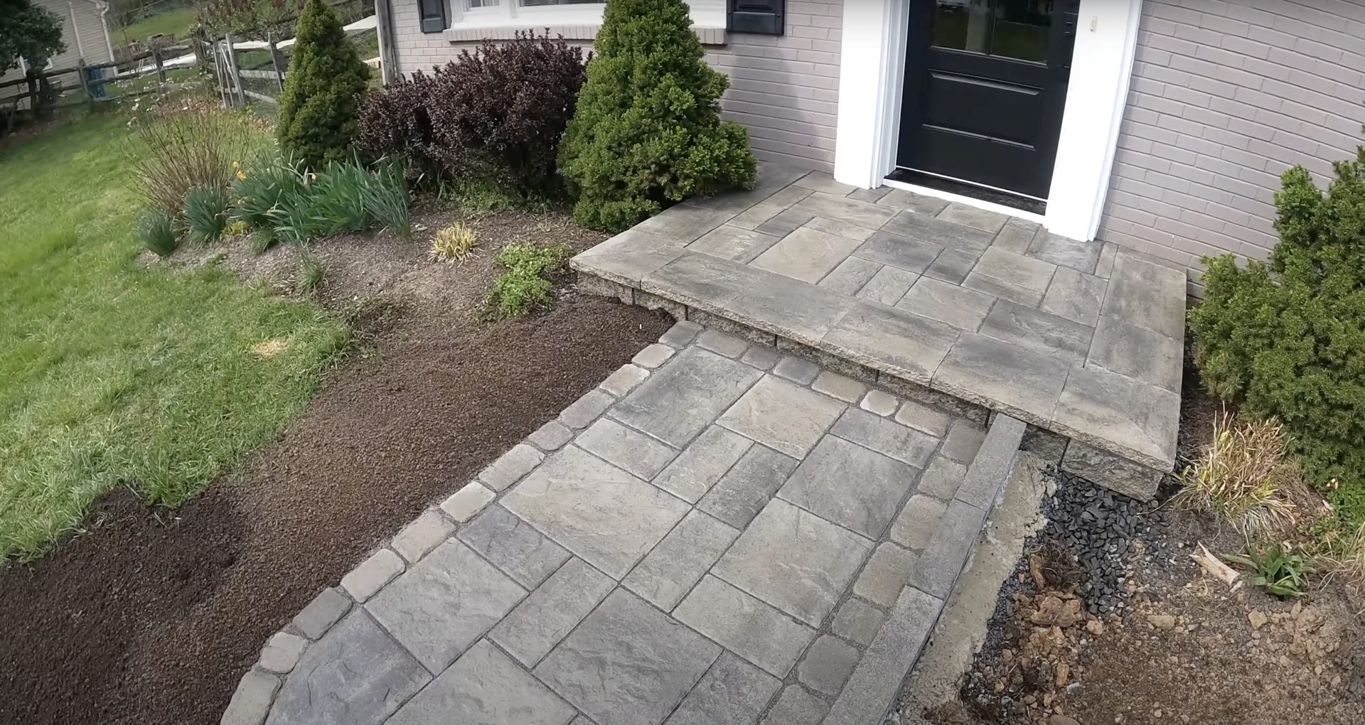 Multi-level concrete patio construction with integrated paver design Multi-level concrete patio and walkway construction with decorative paver accents
